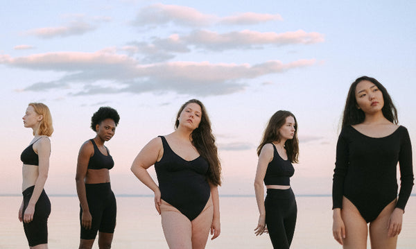 Women standing against cloudy sky